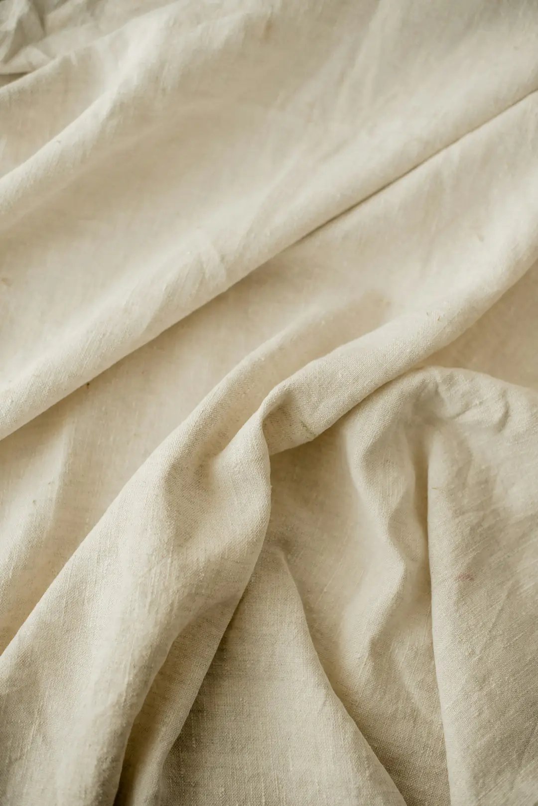 Soft folds of undyed cream linen